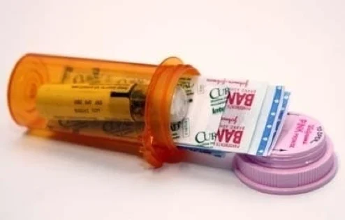 Small pill bottle packed with plasters and first aid essentials as a compact hiking first aid kit
