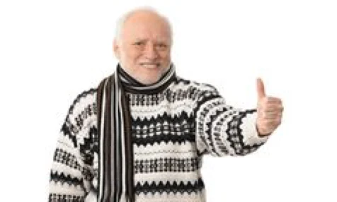 Older man in a knitted jumper and scarf smiling and giving a thumbs up