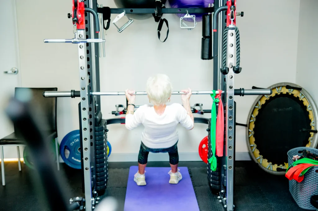 A patient doing a supervised squat in the strength area